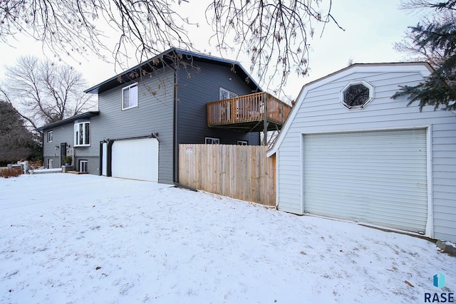 view of snowy exterior featuring a garage