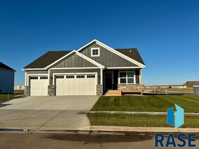 craftsman inspired home featuring a garage and a front lawn