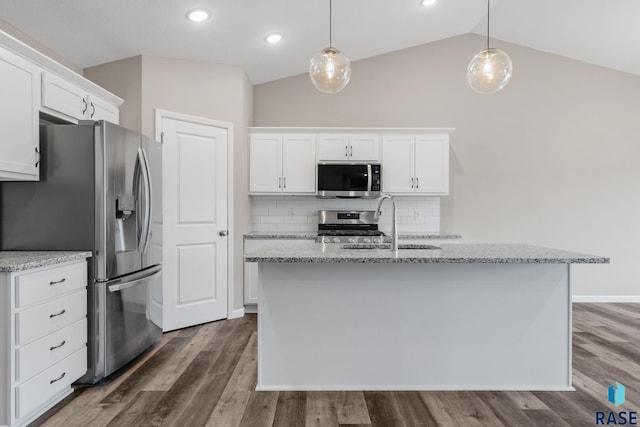 kitchen with dark wood-type flooring, hanging light fixtures, vaulted ceiling, appliances with stainless steel finishes, and white cabinetry