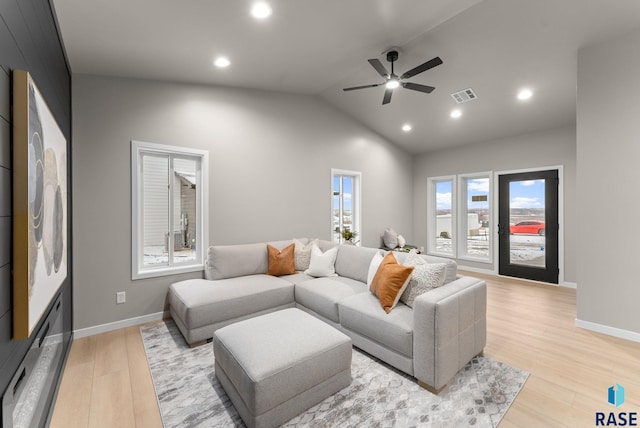 living room with ceiling fan, light wood-type flooring, and vaulted ceiling