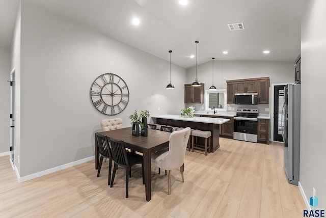 dining room featuring light hardwood / wood-style flooring and high vaulted ceiling