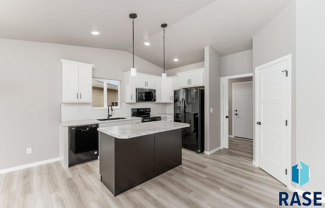 kitchen with a center island, black appliances, sink, hanging light fixtures, and decorative backsplash