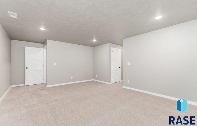 carpeted empty room featuring a textured ceiling