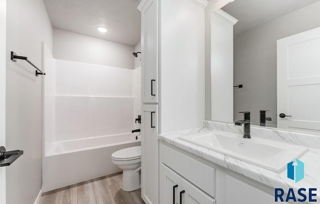 full bathroom with vanity, hardwood / wood-style flooring, toilet, and shower / washtub combination