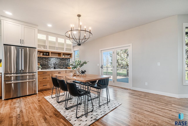 dining space featuring light hardwood / wood-style flooring, a chandelier, and sink