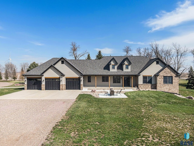 view of front facade featuring a front lawn, a patio, a fire pit, and a garage