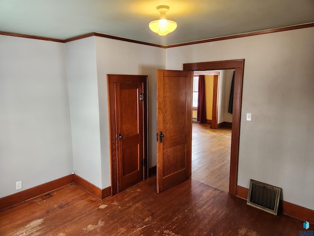 unfurnished room with dark hardwood / wood-style flooring and crown molding