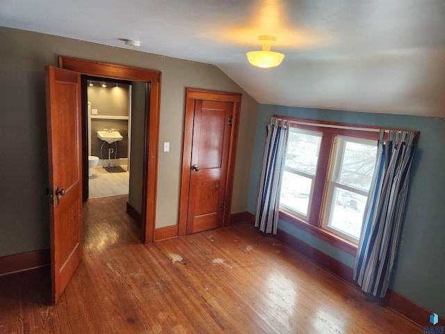 unfurnished bedroom featuring dark hardwood / wood-style floors and vaulted ceiling