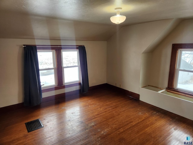 additional living space with dark hardwood / wood-style flooring and vaulted ceiling