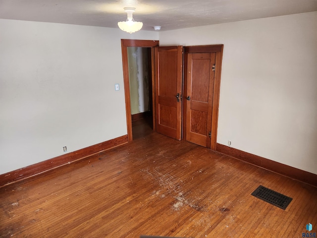 empty room with dark hardwood / wood-style flooring