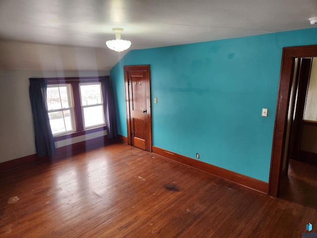 unfurnished room with wood-type flooring and vaulted ceiling