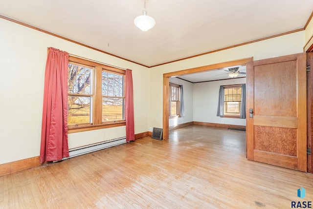 spare room with ceiling fan, ornamental molding, baseboard heating, and light hardwood / wood-style flooring