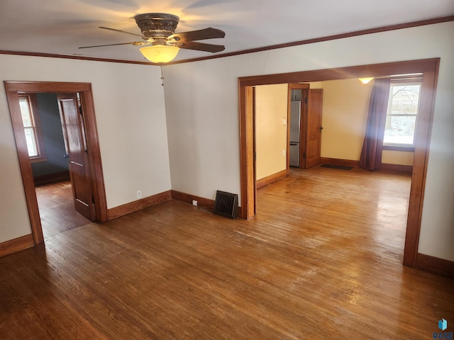 unfurnished room featuring ceiling fan, wood-type flooring, and ornamental molding