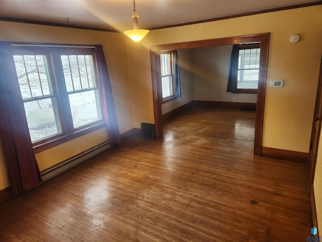 empty room with dark hardwood / wood-style floors, plenty of natural light, and a baseboard heating unit