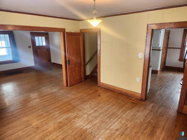 empty room featuring wood-type flooring and crown molding