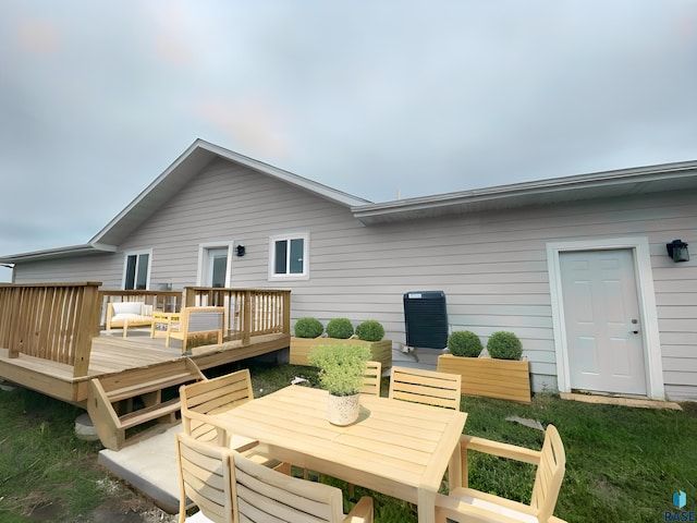 rear view of house featuring a wooden deck