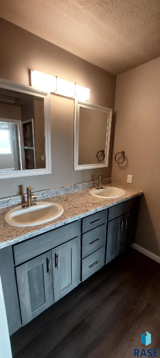 bathroom featuring vanity, hardwood / wood-style floors, and a textured ceiling