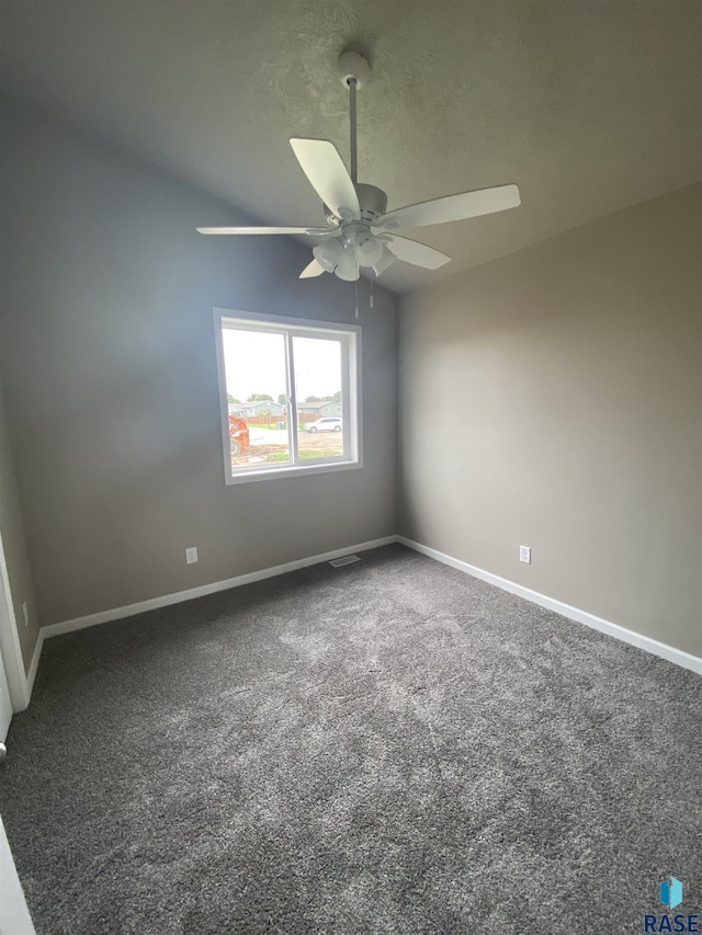 empty room featuring dark carpet and ceiling fan