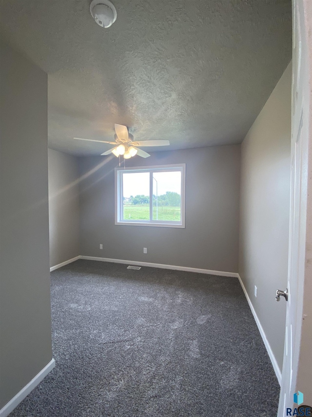 carpeted spare room with ceiling fan and a textured ceiling