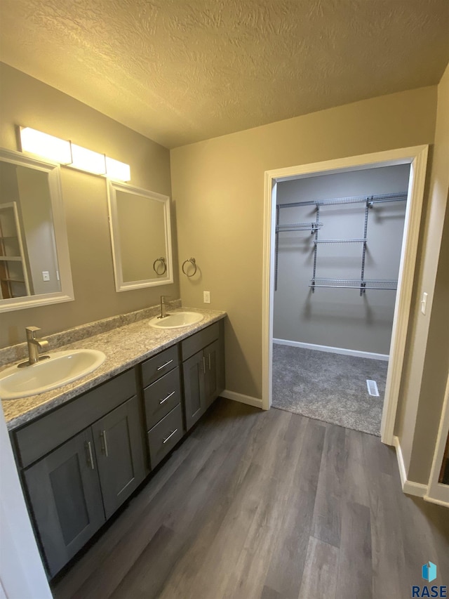 bathroom featuring vanity, hardwood / wood-style floors, and a textured ceiling