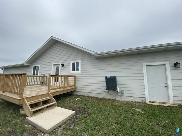 rear view of property with a lawn and a wooden deck