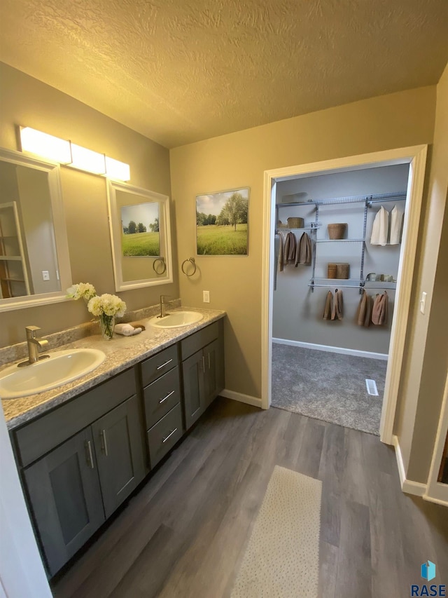 bathroom featuring vanity, hardwood / wood-style floors, and a textured ceiling