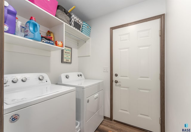 washroom with washing machine and clothes dryer and dark hardwood / wood-style flooring