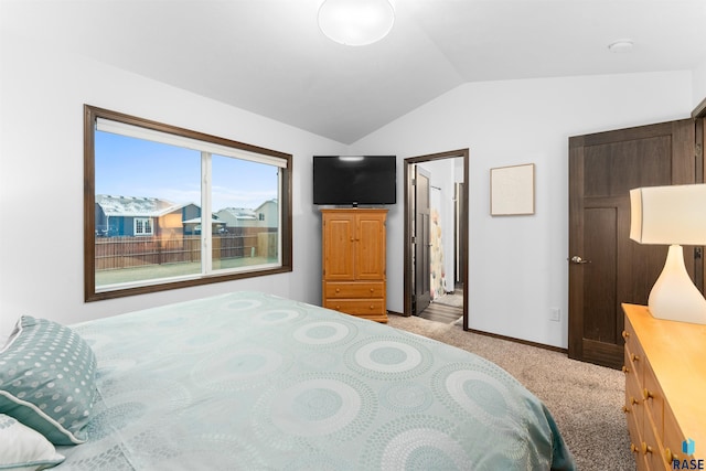 bedroom with light colored carpet and vaulted ceiling