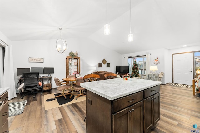 kitchen featuring dark brown cabinets, a kitchen island, hanging light fixtures, and vaulted ceiling