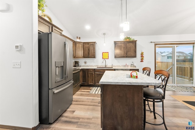 kitchen featuring sink, a center island, hanging light fixtures, light hardwood / wood-style floors, and appliances with stainless steel finishes