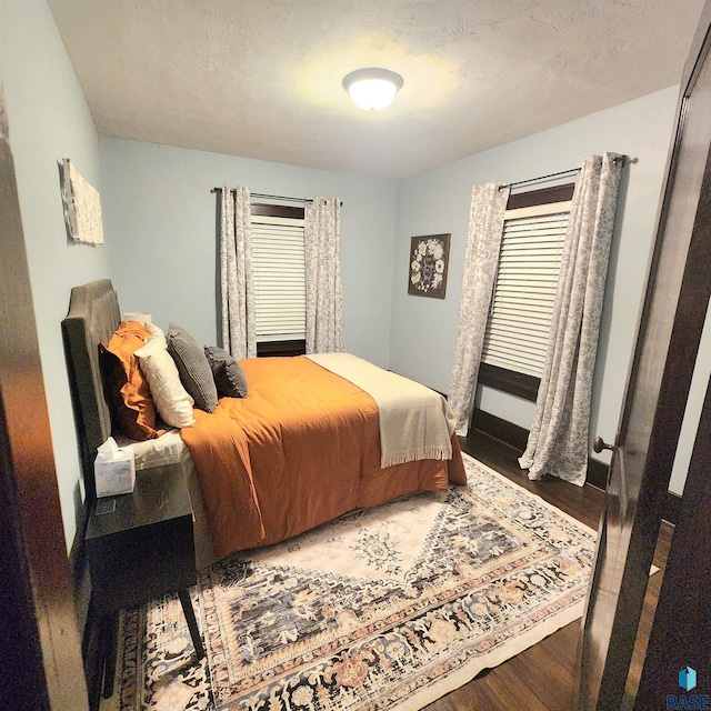 bedroom with hardwood / wood-style floors and a textured ceiling