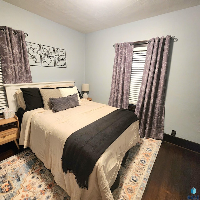 bedroom with dark wood-type flooring