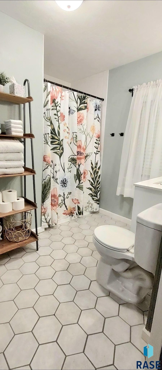 bathroom with toilet and a shower with shower curtain