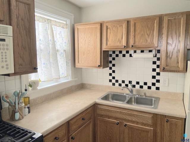 kitchen with sink, decorative backsplash, and a wealth of natural light