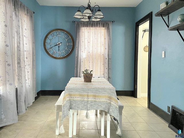 dining area featuring light tile patterned flooring and an inviting chandelier