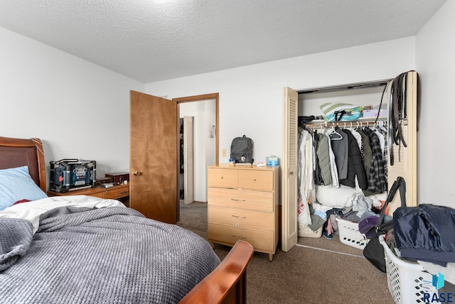 bedroom with a textured ceiling, dark carpet, and a closet