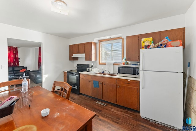 kitchen featuring sink, white fridge, dark wood-type flooring, and black range with electric cooktop