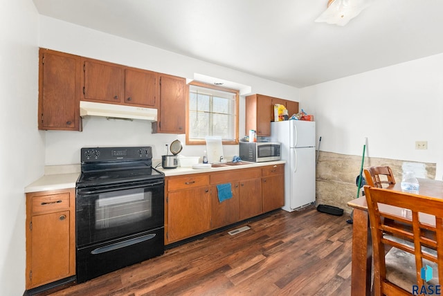 kitchen featuring sink, white fridge, dark wood-type flooring, and black range with electric cooktop