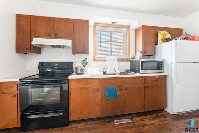 kitchen featuring dark hardwood / wood-style floors, white refrigerator, black range with electric stovetop, and sink