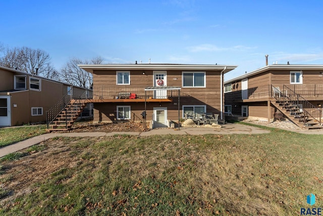 rear view of house featuring a lawn, a patio area, and a wooden deck