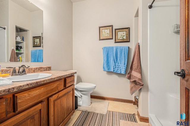 bathroom with toilet, vanity, and tile patterned floors