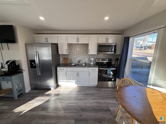 kitchen featuring appliances with stainless steel finishes, dark hardwood / wood-style flooring, white cabinetry, and sink