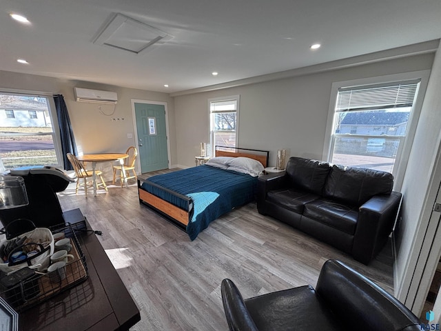 bedroom featuring light hardwood / wood-style floors and an AC wall unit