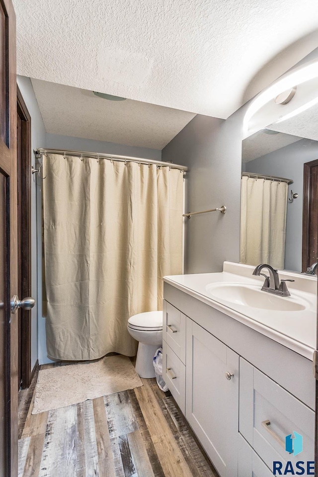 bathroom featuring hardwood / wood-style floors, vanity, and a textured ceiling