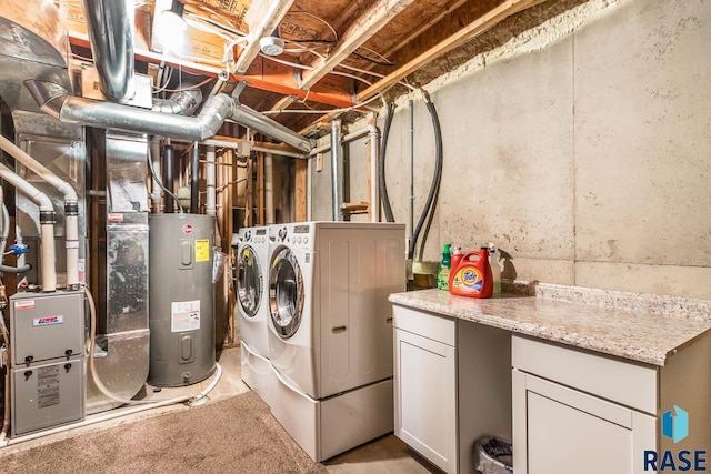 washroom featuring water heater, cabinets, and washer and dryer