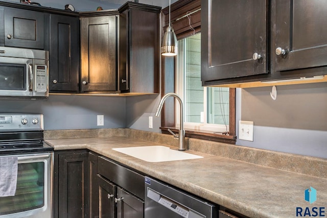 kitchen featuring appliances with stainless steel finishes, decorative light fixtures, dark brown cabinets, and sink