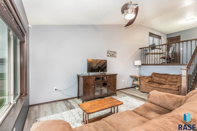 living room with vaulted ceiling, light hardwood / wood-style flooring, and ceiling fan