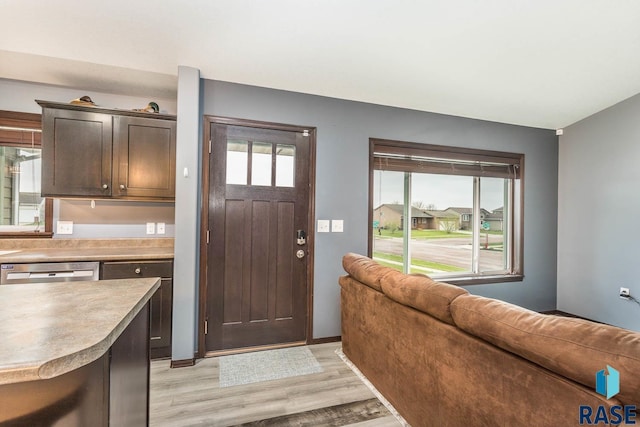 interior space with dark brown cabinets, dishwasher, and light hardwood / wood-style flooring