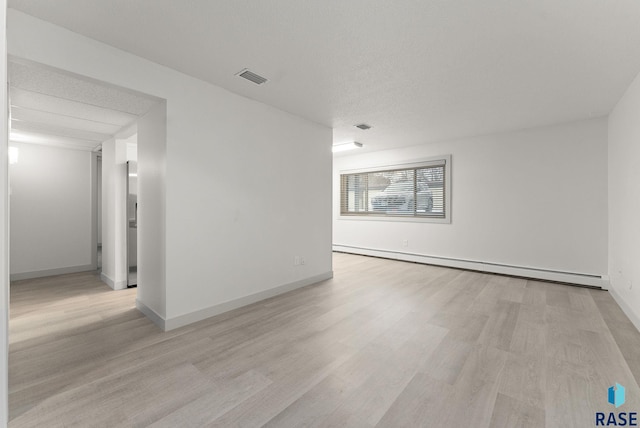 unfurnished room featuring light wood-type flooring and a baseboard radiator