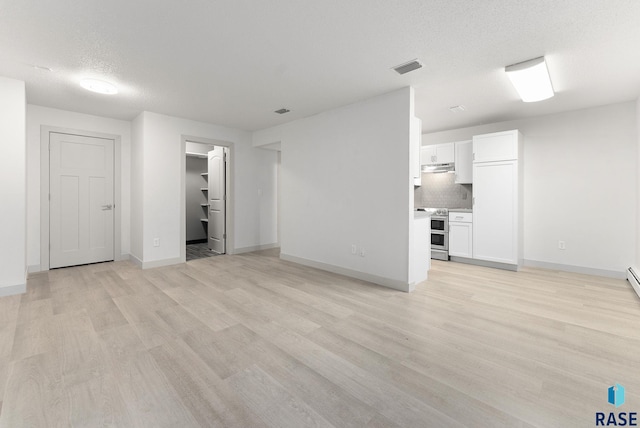 unfurnished living room featuring a textured ceiling and light wood-type flooring